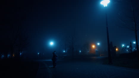 small kid wearing warm clothes walks by the paved road. child in the park late in the evening.