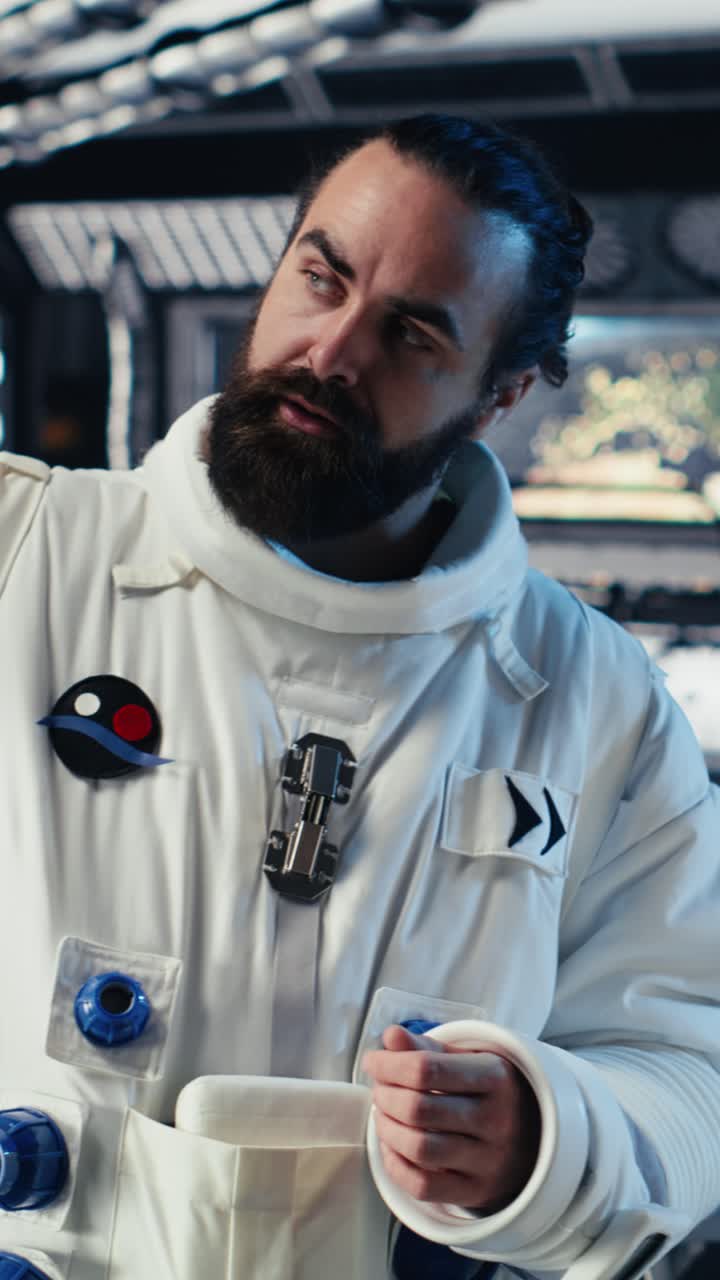 Vertical video Astronaut reading mission plan on tablet before stepping out of space station