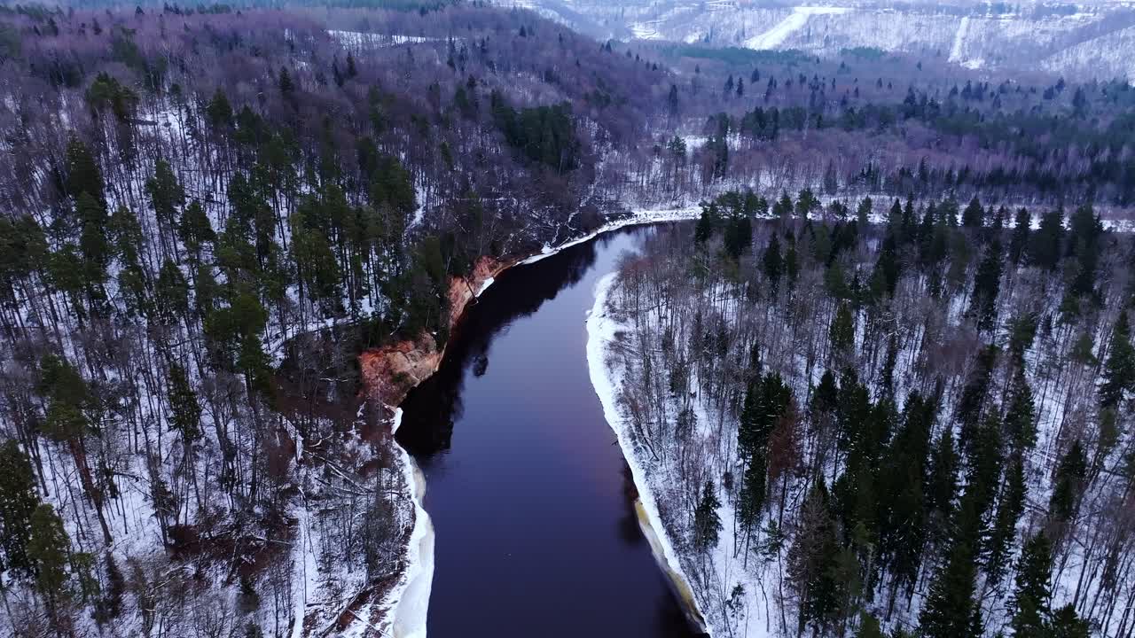 Valle del Gauja innevata vicino a Sigulda, il drone sorvola la Grotta del Diavolo, scogliere vivide