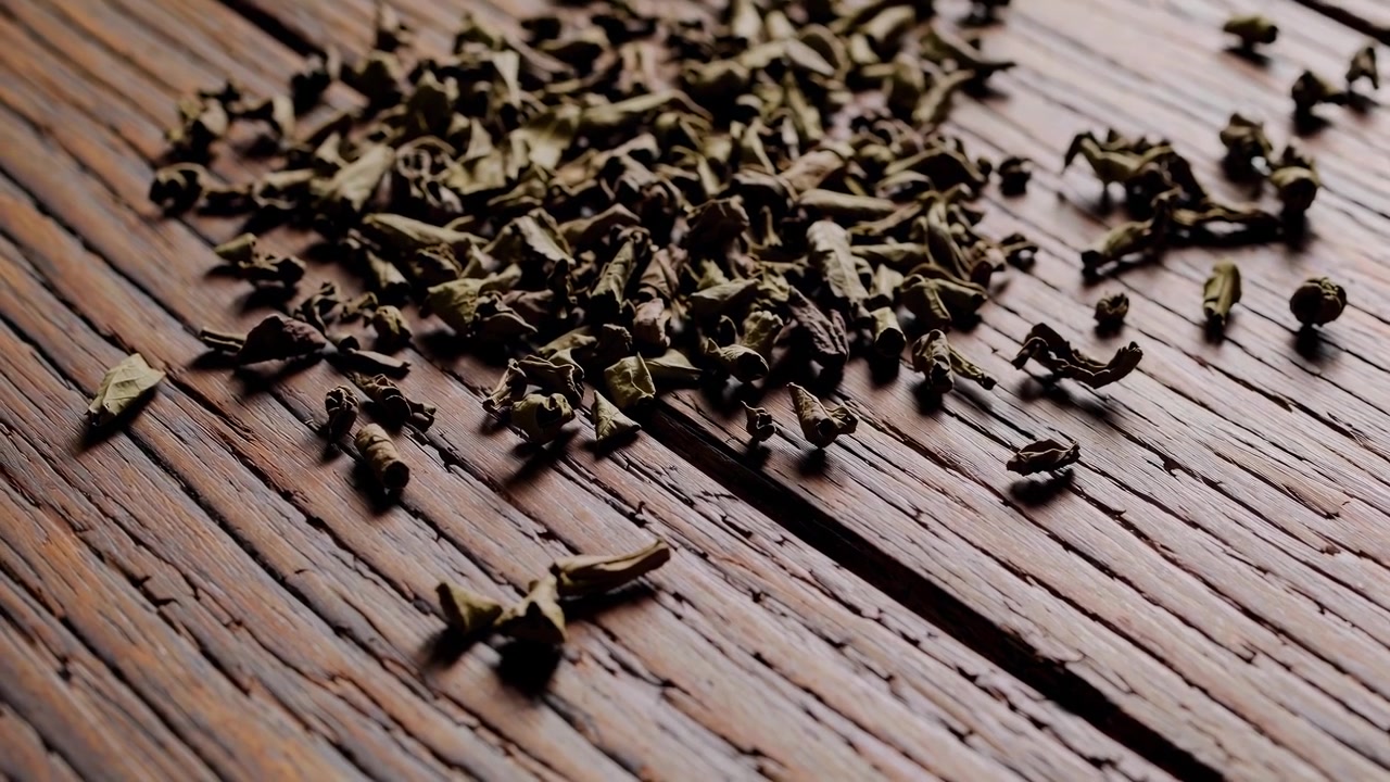 素朴な木製のテーブルに散らばる乾燥した緑茶の葉