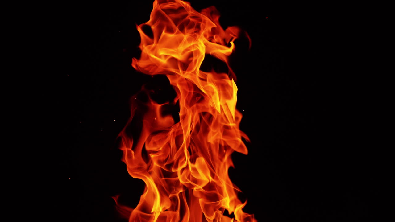 Long fire flame rising up. Burning bonfire in the darkness isolated close up.