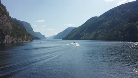 Aerial-shot-following-a-speedboat-through-Mesmerizing-Norwegian-fjord-Scene