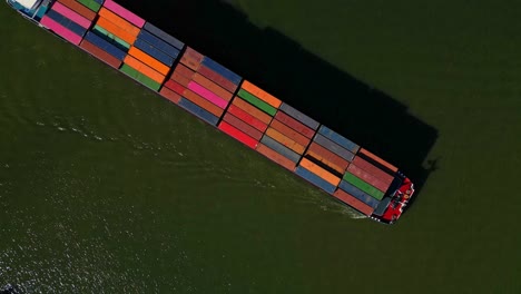 huge cargo vessel top down aerial view navigating through the canal in dordrecht, the netherlands