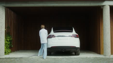 woman charging an electric car in a garage