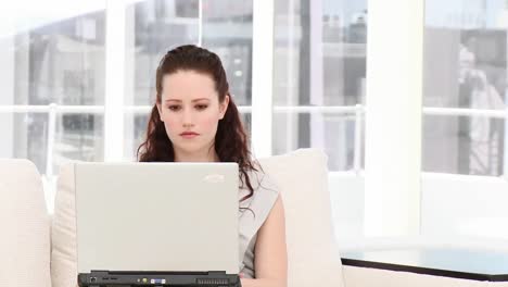 mujer de negocios seria trabajando en una computadora portátil