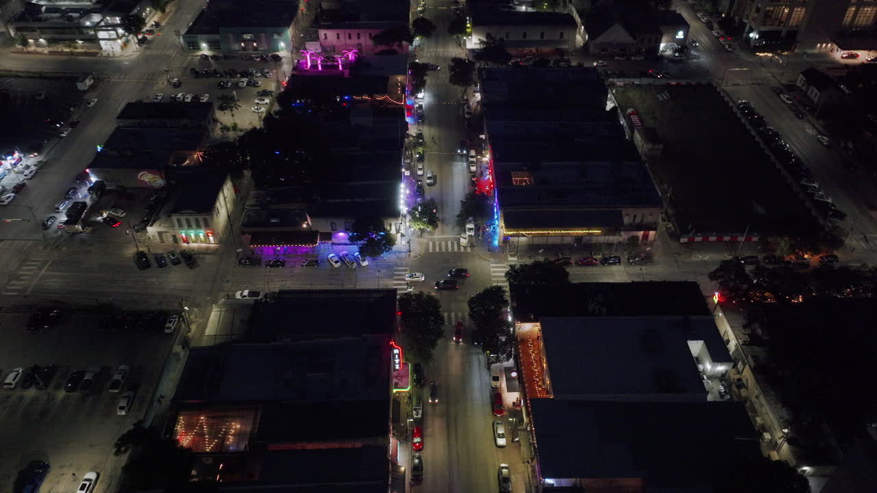 Aerial Night View of a Downtown City Street with Neon Lights and Traffic