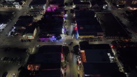 aerial night view of a downtown city street with neon lights and traffic