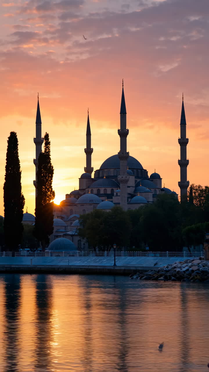 Grande moschea con minareti riflessa nell'acqua al tramonto