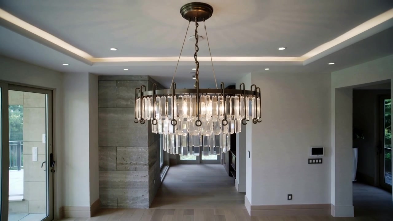 Pulling back camera revealing crystal chandelier in finished living area to show balcony
