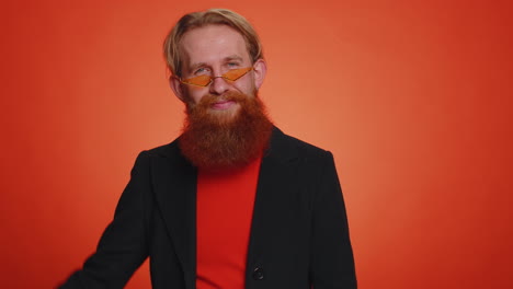 bearded optimistic young man showing victory sign, hoping for success and win, doing peace gesture