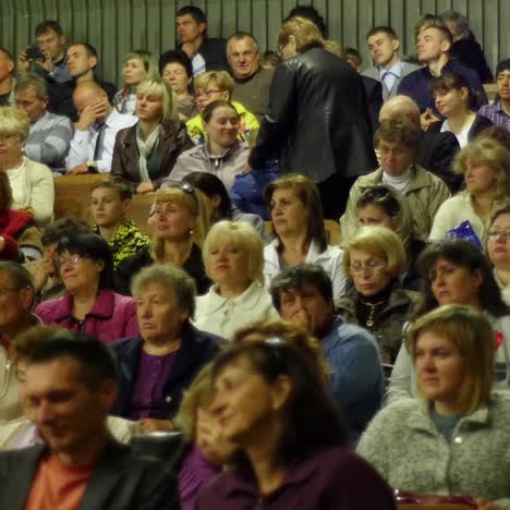crowd of people to sitting and listening in a large hall