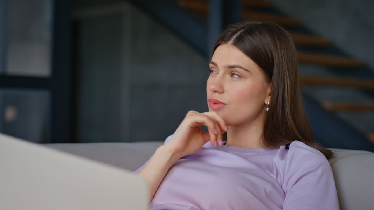 Thoughtful freelancer reading email using laptop at couch closeup. Woman online