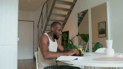 hombre trabajando en una computadora portátil en casa