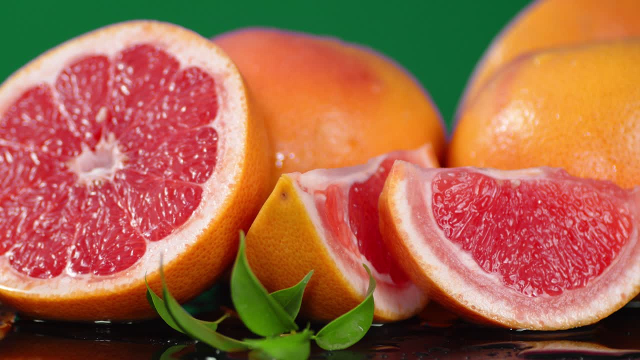 Cut the slices of fresh grapefruit with leaves rotates slowly.