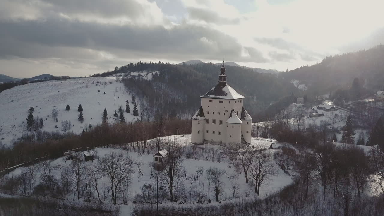 volando hacia un nuevo castillo en la ciudad minera banska stiavnica en invierno, soleada toma aérea