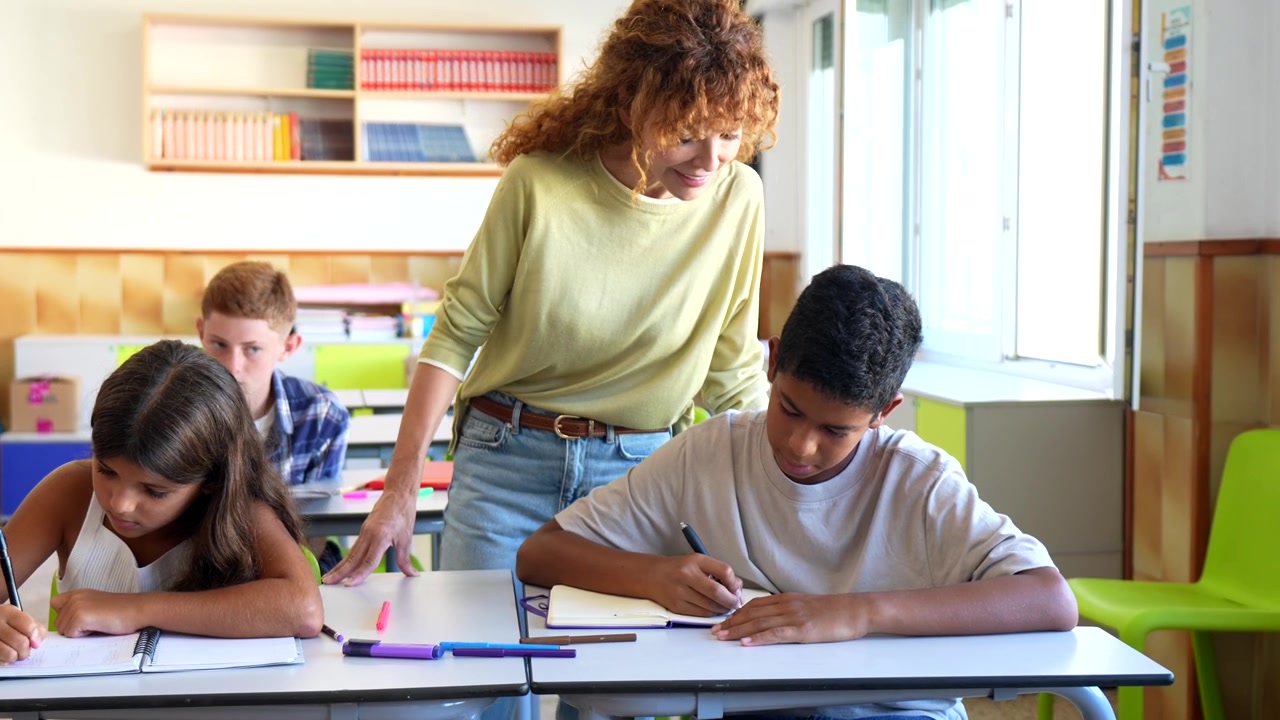 Teacher Helping Students with Schoolwork in Classroom