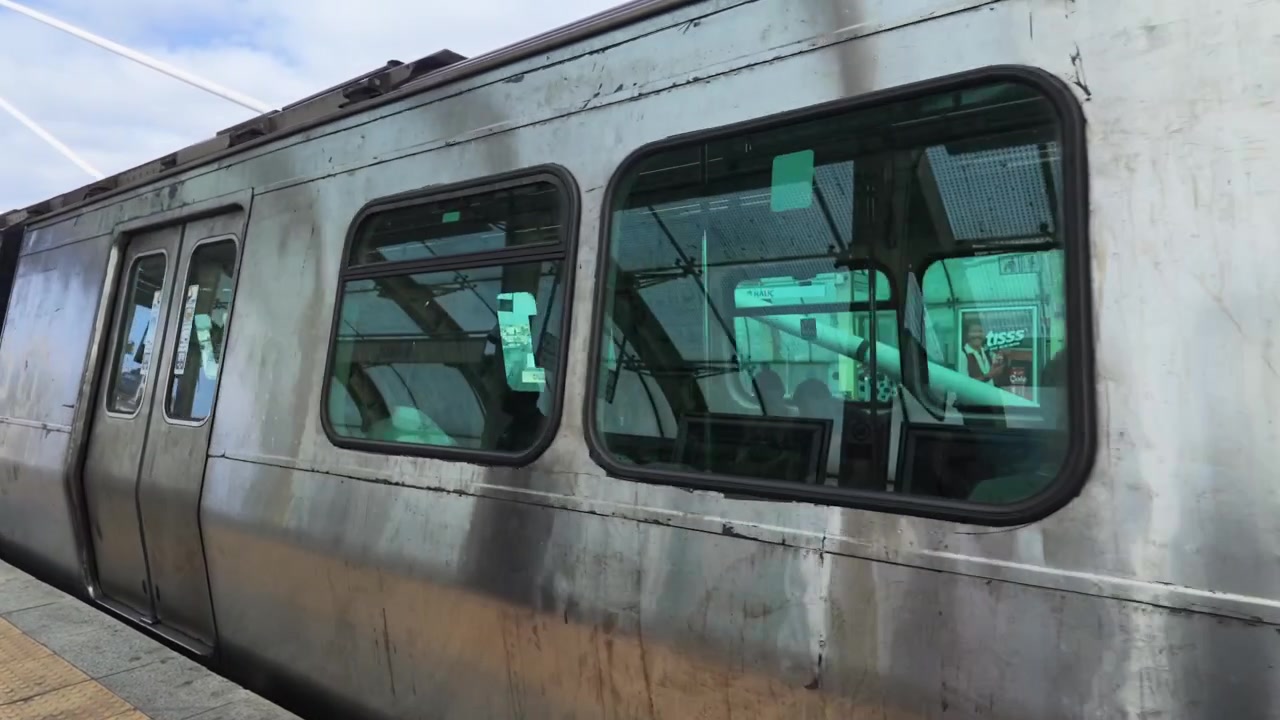 近代的な駅のホームから出発する通勤列車