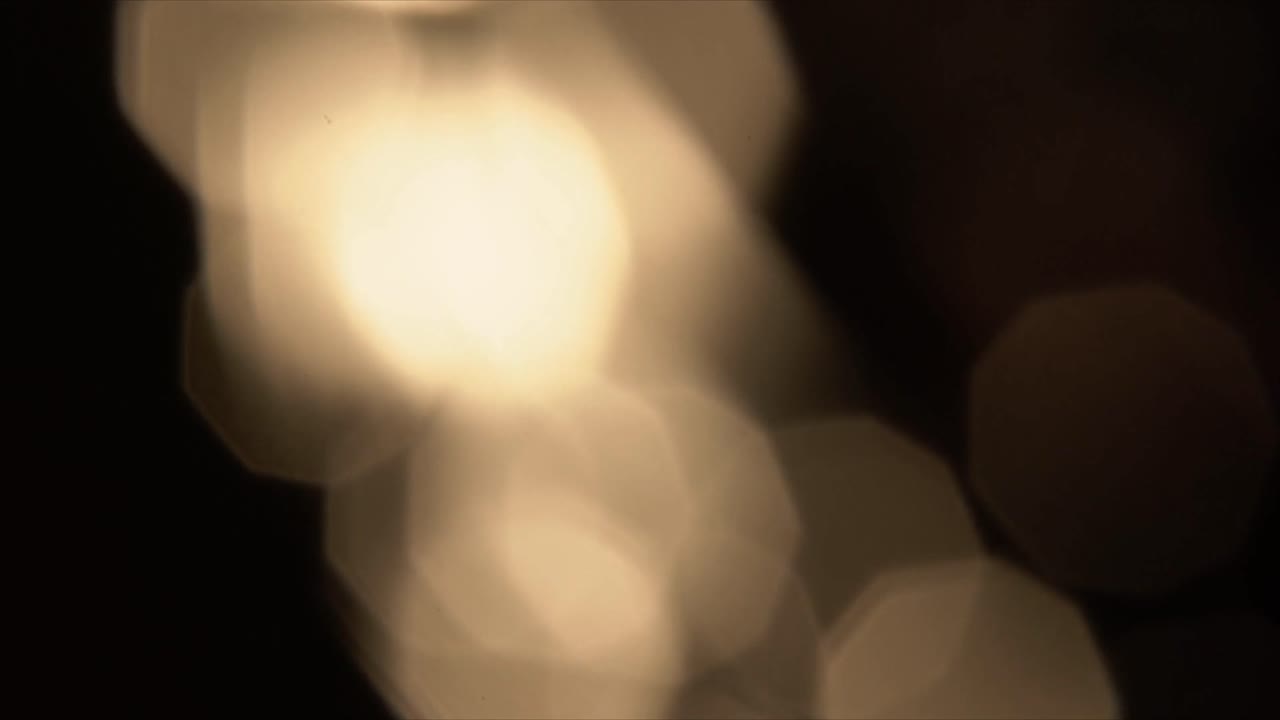 Fughe di luce bokeh dorate e morbide su sfondo scuro