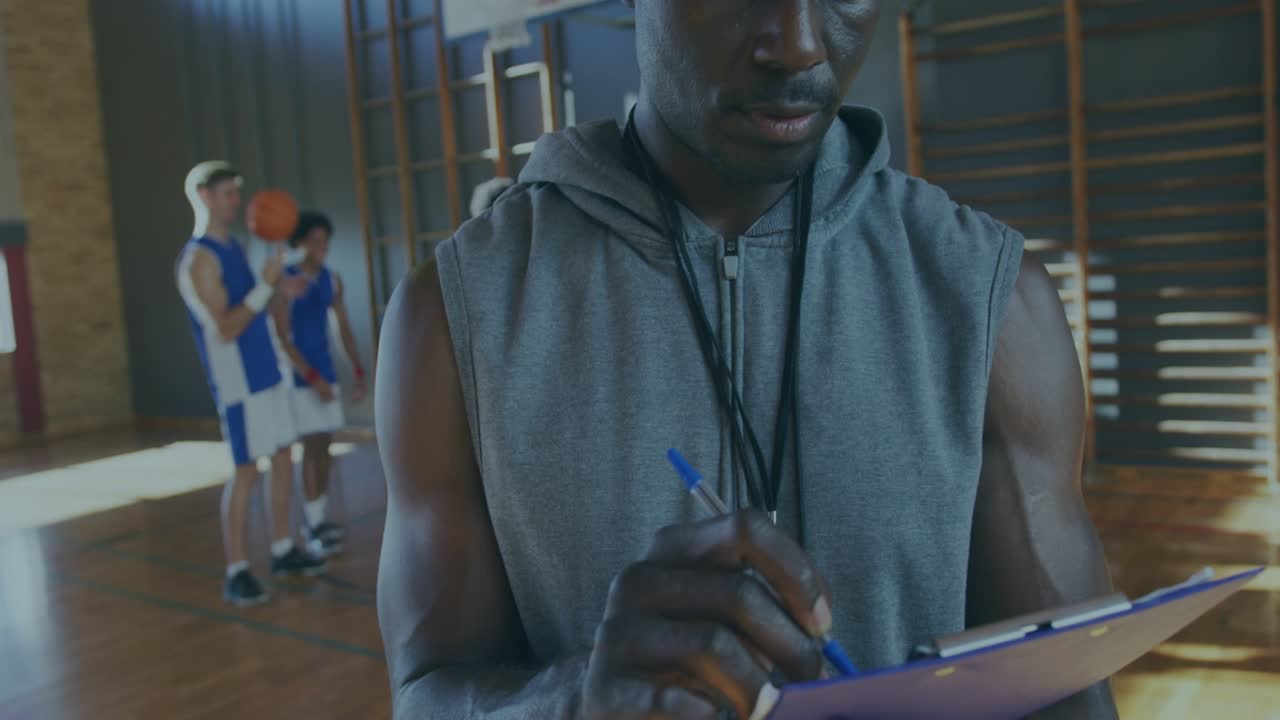 Coach tapping clipboard, writing, scanning basketball players, analytics overlaying tracking stats