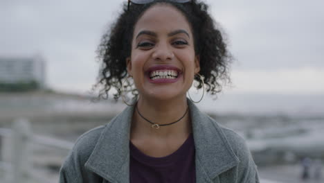 Retrato-De-Una-Joven-Hispana-Con-Peinado-Rizado-Riendo-Feliz-En-La-Playa-Junto-Al-Mar