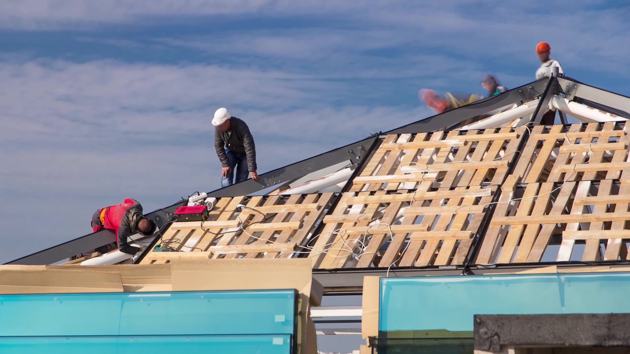 Builders and carpenters working on the roof timelapse. Blue cloudy sky on backgroung