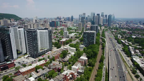 aerial reverse shot overlooking the shaughnessy village and the boulevard ville-marie, summer in montreal