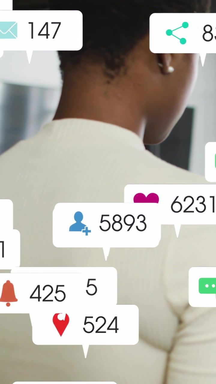 Vertical video: Woman at desk getting social alerts bubbles filling head then fading showing stress
