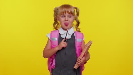 lächelnde lustige schulmädchen macht ein humorvolles gesicht mit gekreuzten augen, spielt dummkopf, amüsiert sich, hirnlos