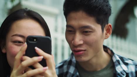 Handheld-Ansicht-Eines-Vietnamesischen-Paares,-Das-Sein-Mobiltelefon-Benutzt