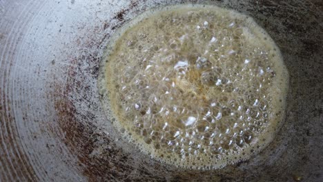 frying anchovies in the hot palm oil and metal pan