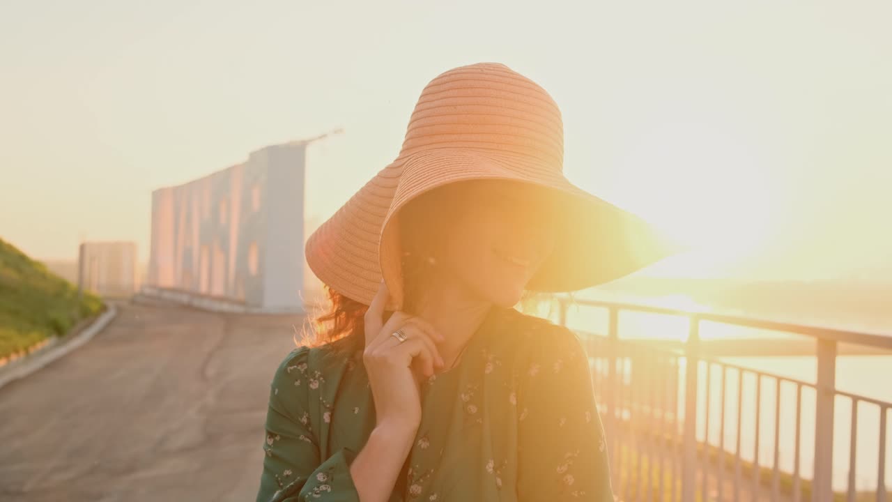 Woman in a hat at sunset