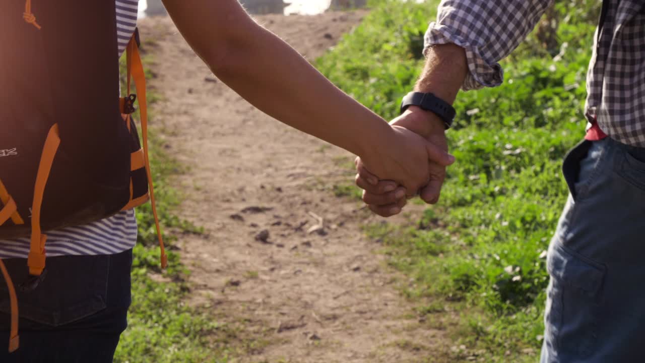 joven pareja encantadora mochileros turistas caminando de la mano hacia el acueducto romano arcos en el parco degli aquedotti ruinas del parque en roma en romántico amanecer brumoso con guitarra y saco de dormir cámara lenta