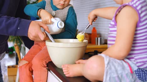 father and children pouring and stirring milk 4k