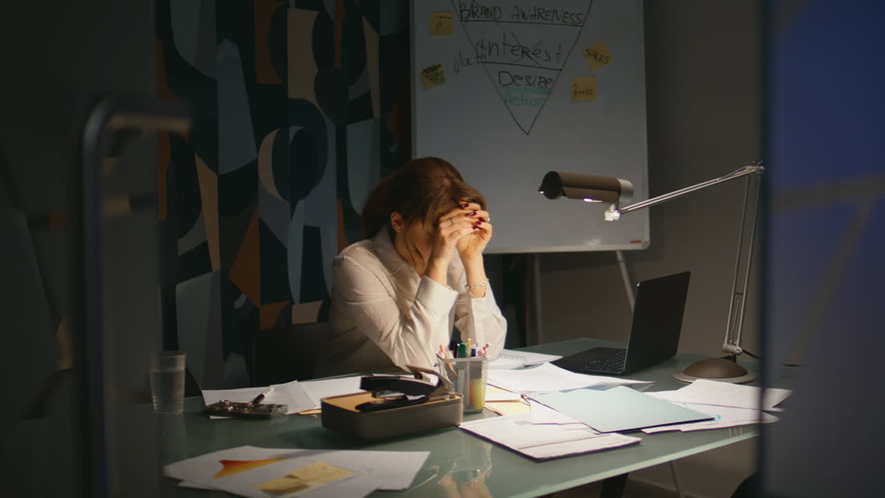 Primo piano di un contabile che esamina documenti cartacei lavorando fino a tardi in ufficio