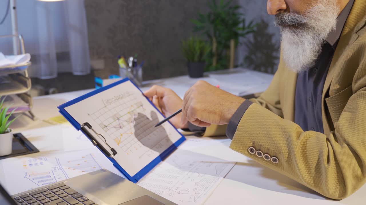 Office worker examining chart, thoughtful.