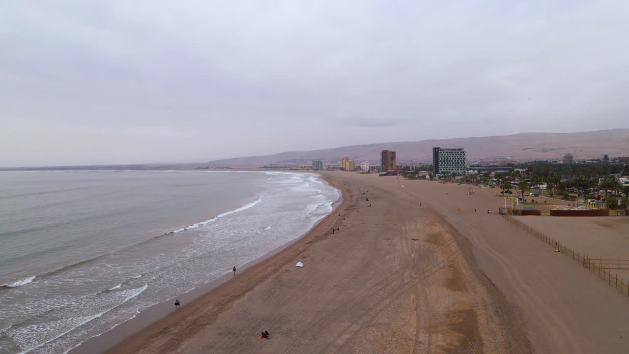 drone disparado volando a lo largo de la playa en arica, chile en un día nublado