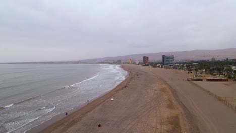 drone disparado volando a lo largo de la playa en arica, chile en un día nublado