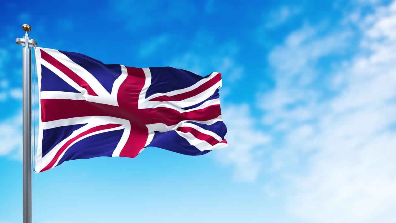 The national flag of the United Kingdom flying in the wind. Outdoors and sky in the background.