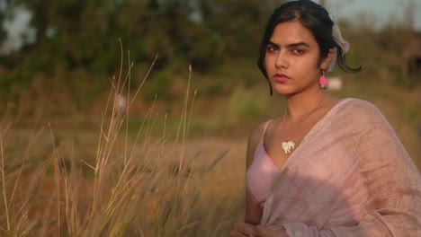 Serene-woman-in-vintage-attire-enjoying-golden-hour-in-a-field,-profile-view,-soft-focus