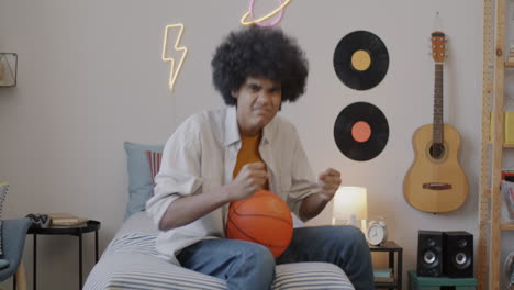 teenage boy with basketball in bedroom