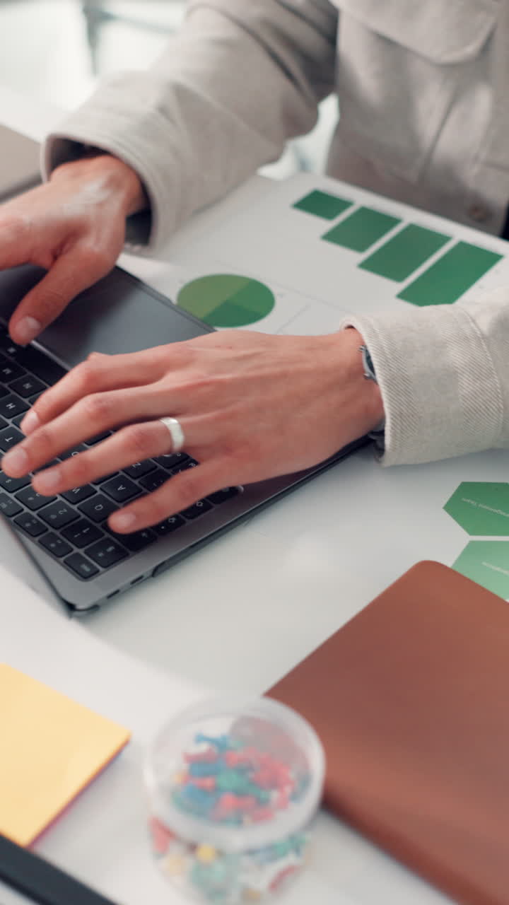 Nærbillede af hænder, der taster på et bærbart tastatur på et kontor