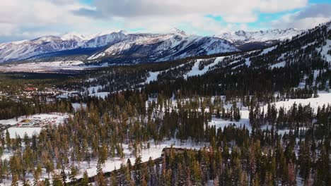 main lodge mammoth mountain ski resort car parking lot california aerial drone chairlifts inyo national forest skiing snowboarding winter sunny blue sky ski trail runs afternoon forward motion