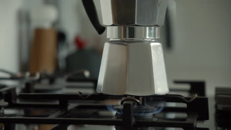 traditional bialetti moka express coffee maker brewing coffee on a gas stove in the morning