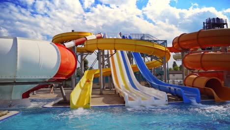 waterslides with blue pool. colorful waterslides in aquapark on nature