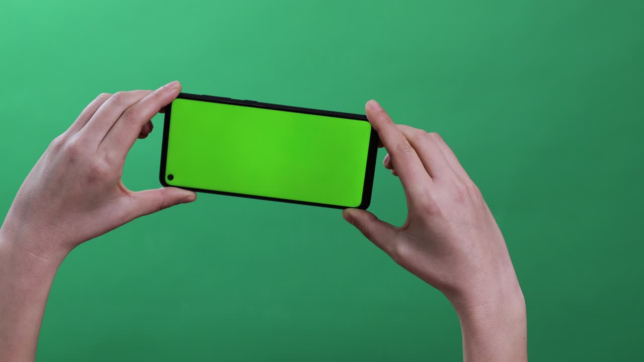 woman holding a smartphone on chroma key green background