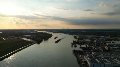 Aerial-Dolly-Over-Beneden-Merwede-During-Sunset-With-Silhouette-Of-Barge-Travelling-Along