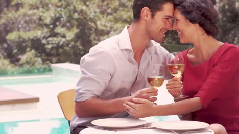 smiling couple with wine glasses hugging