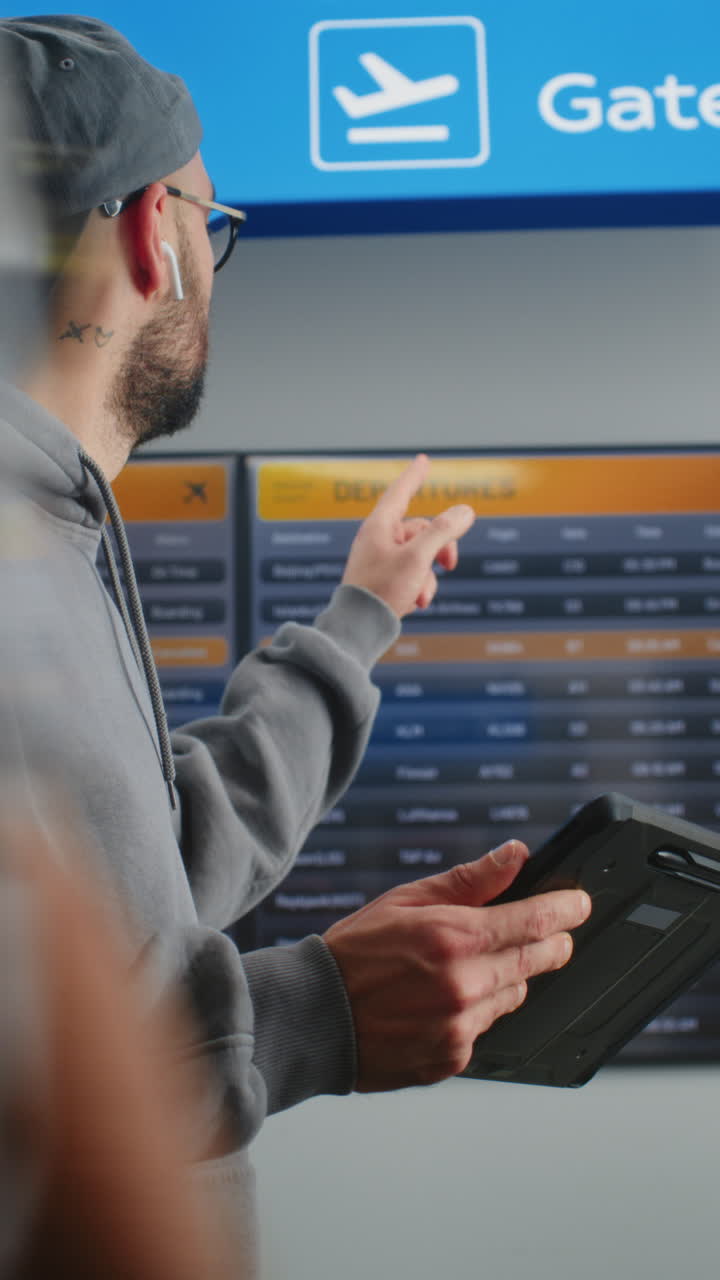 Man Checking Flight Information at Airport Departure Board