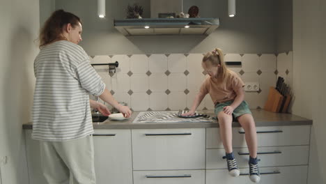 mother and daughter doing dishes in kitchen