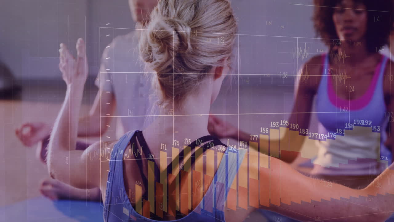 Yoga participants practicing meditation in studio displaying animated health graphs above yoga mats